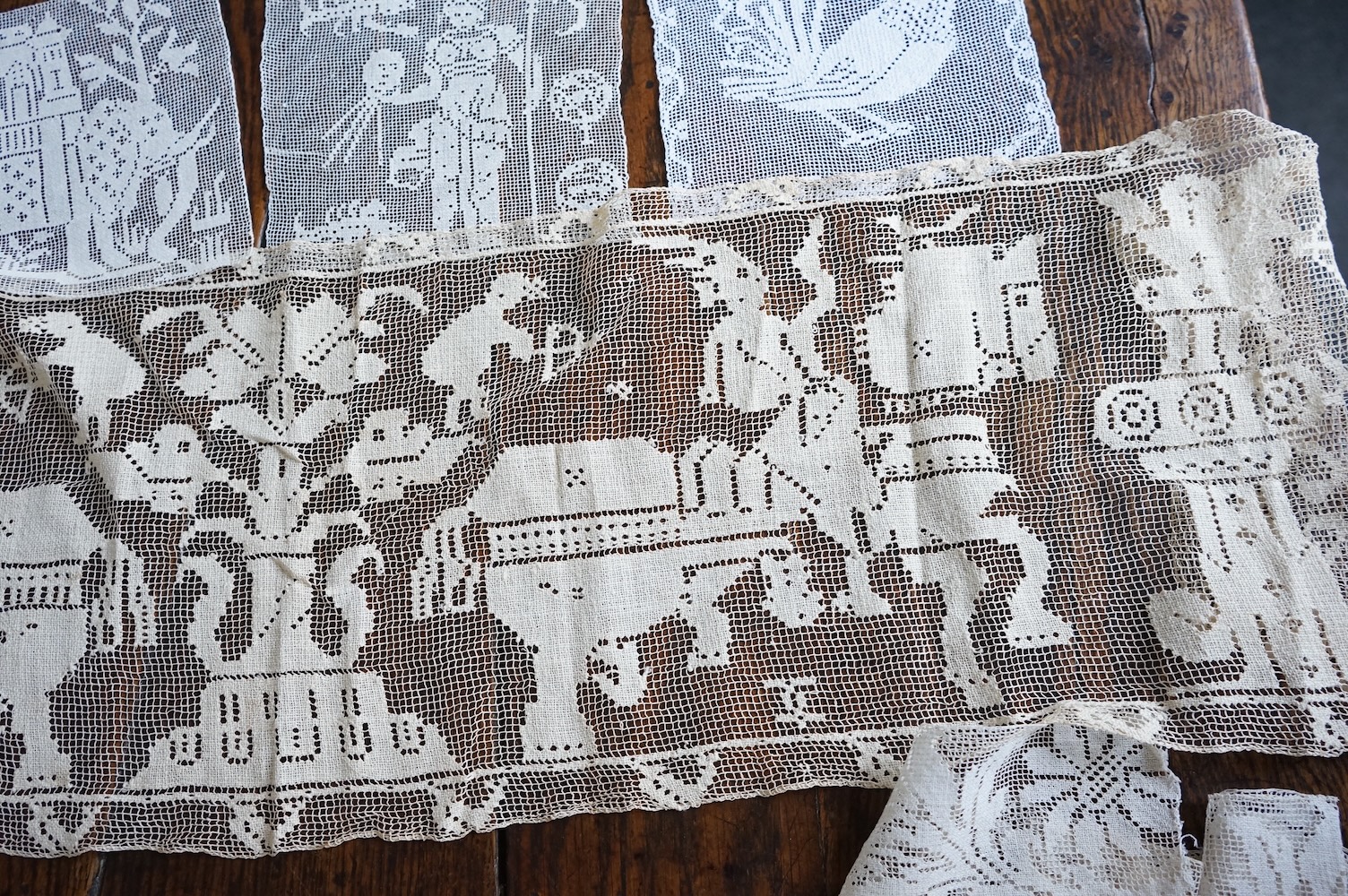 A good collection filet lace including a wide figurative elephant panel, square inserts, mats, trimming etc, with two Normandy lace mats, a cutwork mat and bobbin lace inserts.(40). Fillet panel 112cm long x 27cm wide. C
